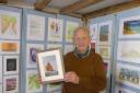 Peter Wade-Martins, chair of Dereham Heritage Trust, Holding a replica of a John Craske picture.