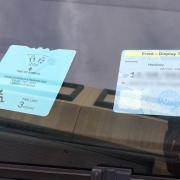 A blue badge, properly displayed on the front dashboard of a vehicle.